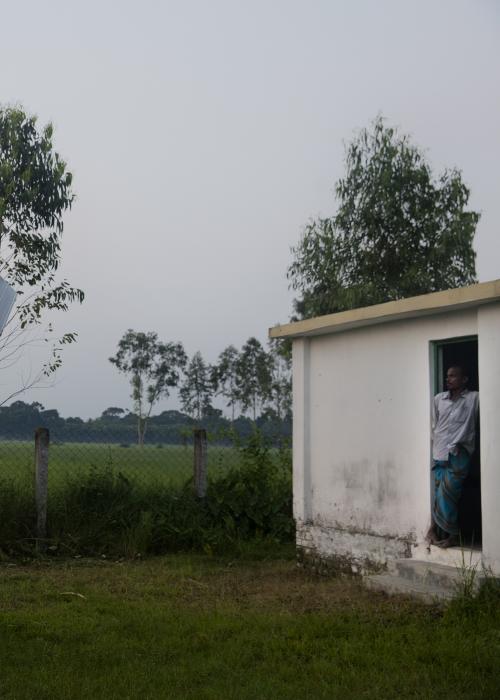 Man in rural landscape looking at solar panel