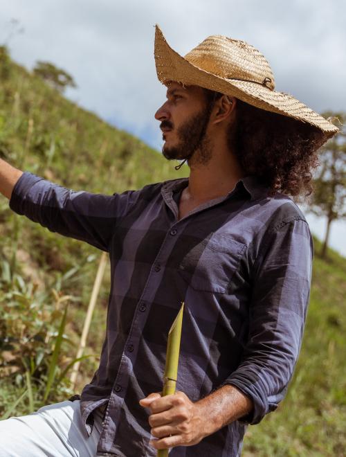 A man holds sticks on a steep hillside