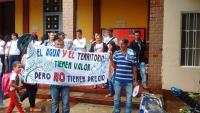 A group of demonstrators hold a sign protesting an oil project in Colombia.