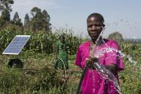 Women irrigating a farm using solar-powered water pump in Kenya.