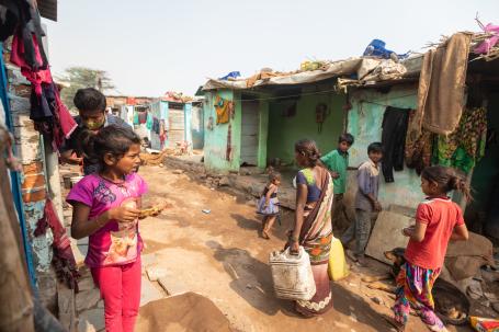Woman walking with water jugs in Ahmedabad streets