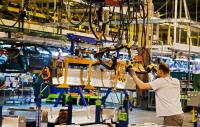 An autoworker moves a lithium-ion battery into position at a car manufacturing plant in Detroit.