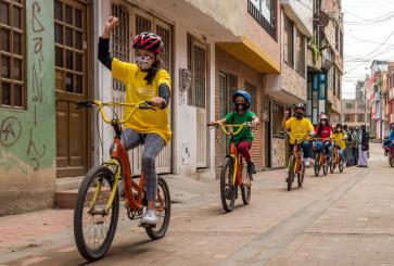 Children biking in line on streets of Calle Colombia.