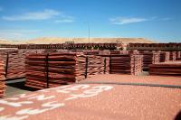 Two men checking train with copper cathodes for dispatch in Escondida, Chile