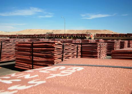 Two men checking train with copper cathodes for dispatch in Escondida, Chile
