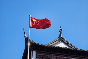 A chinese flag flying on top of a building.