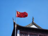 A chinese flag flying on top of a building.