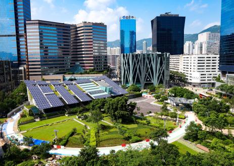 Solar panels in park surrounded by skyscrapers