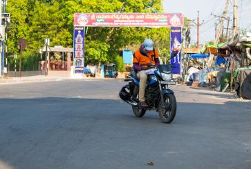 Person riding motorcycle in India during coronavirus pandemic