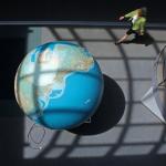 Aerial view of globe and person walking in office.