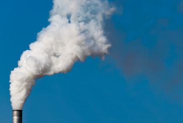 smoke stacks over blue sky.