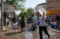 A woman carries water during a blistering hot day in New Delhi, India.