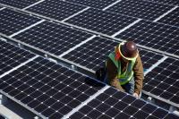 Technician installing solar panels on roof.