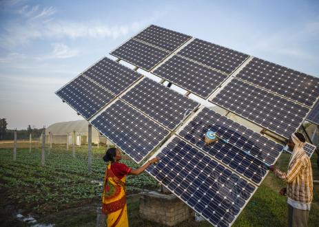 Farm workers clean the solar panels of a solar water pump at the farms of Gurinder Singh a farmer with a land holding of 80 acres in Jagadhri.