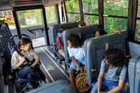 Kids talking on a school bus.