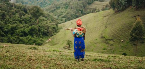 Local Woman Standing in the fields and looking in the forest