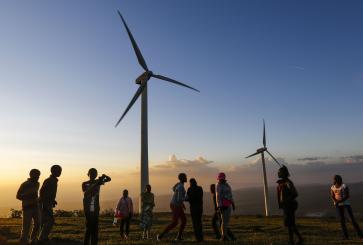 People in front of wind turbines.