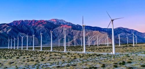 Windmills next to a mountain in sunset