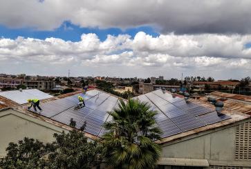 Installation of solar panels to a building roof in Africa