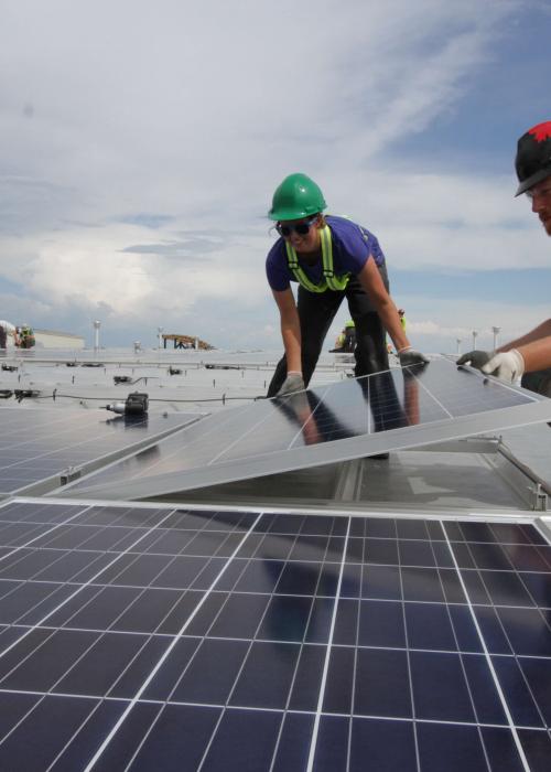 Woman and man installing a solar panel