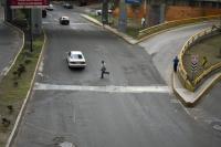 A person runs across a wide street.