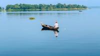 A man in a boat on a body of water in Chittagong, Bangladesh