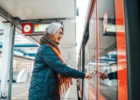 Woman opening train door with bicycle sign