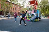 Children enjoy the vibrant new playground in the recently redesigned green schoolyard at P.S. 38K in New York, where fresh equipment and engaging spaces foster creativity and play.